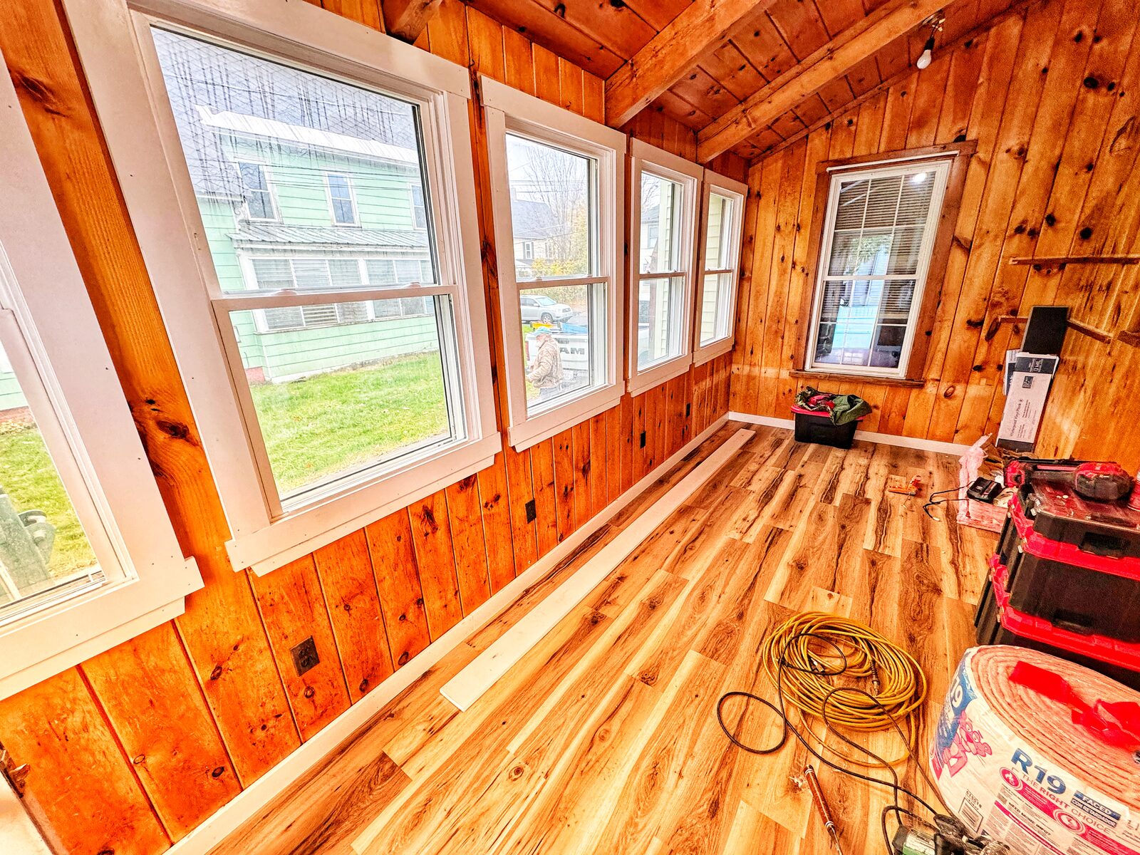 Sunroom mid-build with new flooring, insulation, and tools